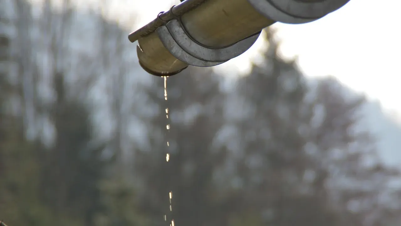 Rainwater dripping from a gutter